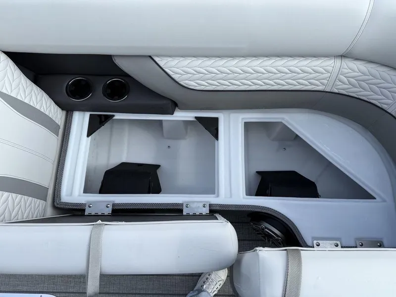 Slide: The Image of 2025 Godfrey Monaco 235 SFL boat interior storage compartments with quilted seating and cup holders. - 4