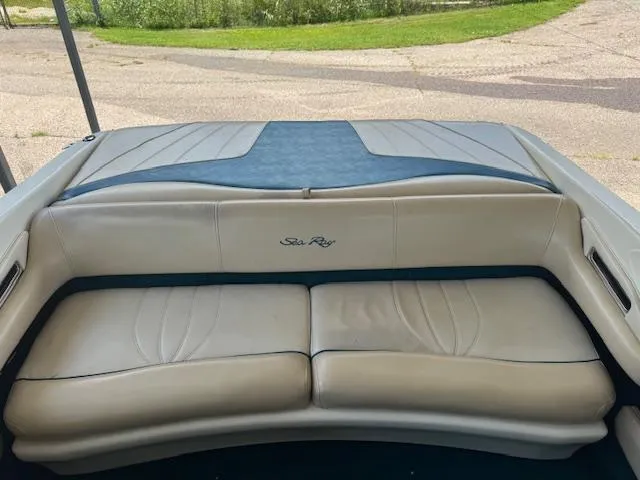 Slide: The Image of 1998 Sea Ray 210 Signature boat interior with beige seating and blue accents. - 10
