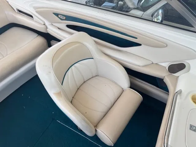 Slide: The Image of 1998 Sea Ray 210 Signature boat interior with white seating and teal accents. - 11