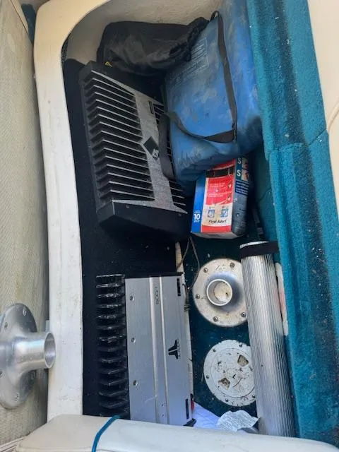 Slide: The Image of Storage compartment in a 1998 Sea Ray 210 Signature boat with audio equipment and supplies. - 14