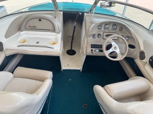 Slide: The Image of 1998 Sea Ray 210 Signature boat interior with steering wheel and dashboard controls. - 8