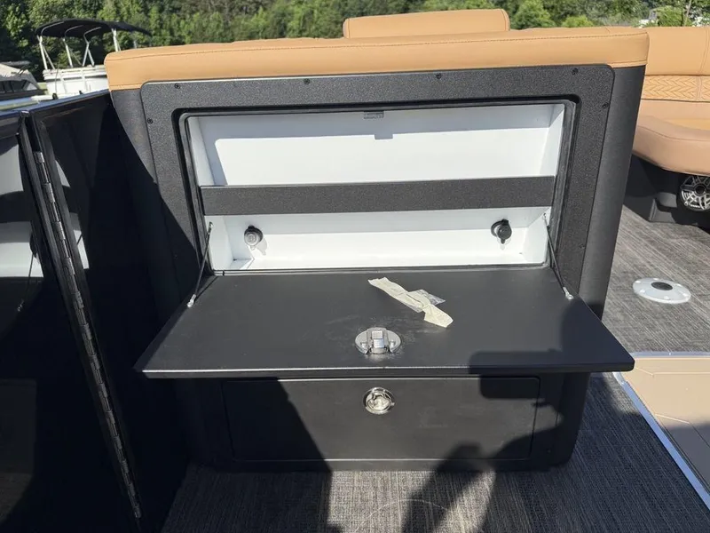 Slide: The Image of Storage compartment on 2025 Godfrey Monaco 235 SFL iMPACT pontoon boat, open with latch visible. - 17