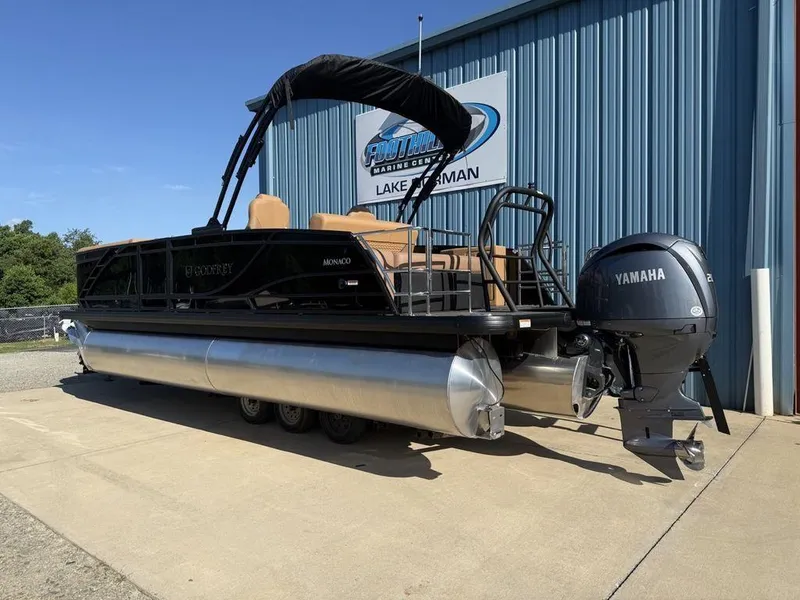 Slide: The Image of 2025 Godfrey Monaco 235 SFL pontoon boat with Yamaha engine, parked outside a marine center. - 5