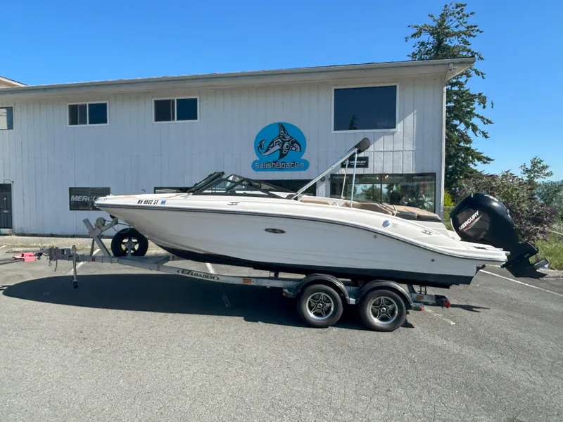The Image of 2021 Sea Ray 21 SPX OB boat on trailer, parked outside a building. - 1