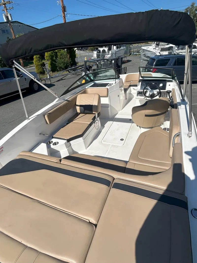 Slide: The Image of 2021 Sea Ray 21 SPX OB boat with tan seating and black canopy in a marina. - 11