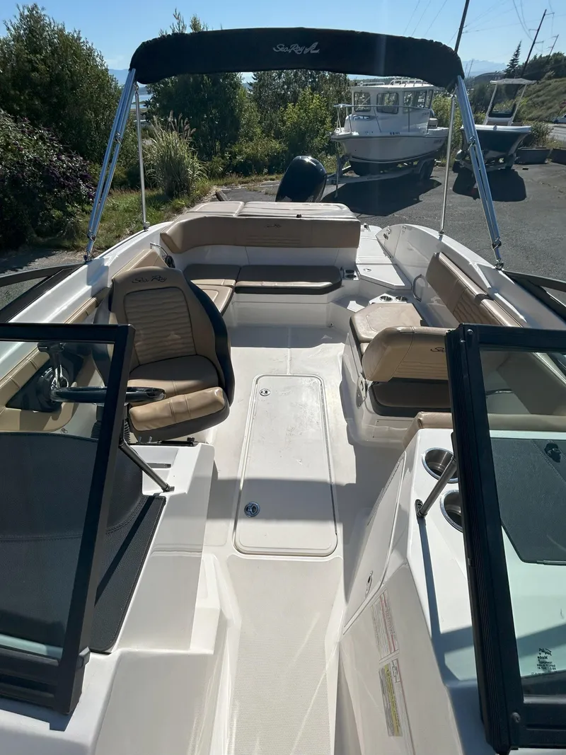 Slide: The Image of 2021 Sea Ray 21 SPX OB boat interior with beige seating and canopy. - 8