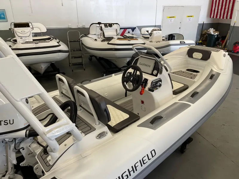 Slide: The Image of 2024 Highfield Sport 390 inflatable boat in showroom, featuring Garmin navigation system. - 3