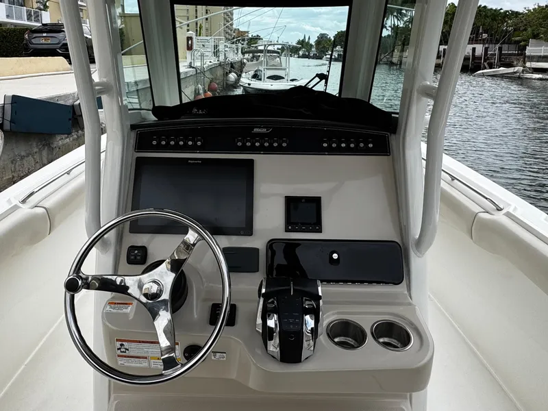 Slide: The Image of 2020 Boston Whaler 280 Outrage boat console with steering wheel and navigation controls. - 16
