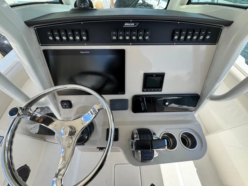 Slide: The Image of 2020 Boston Whaler 280 Outrage helm with steering wheel, controls, and navigation display. - 18