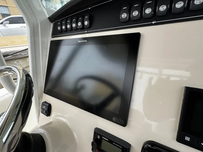 Slide: The Image of Control panel of a 2020 Boston Whaler 280 Outrage with Raymarine display and switches. - 22