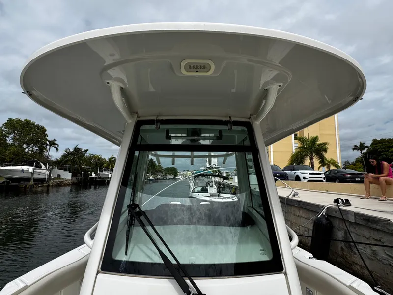 Slide: The Image of 2020 Boston Whaler 280 Outrage boat docked by a canal with palm trees. - 25