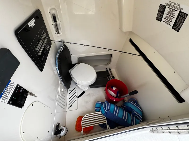 Slide: The Image of 2020 Boston Whaler 280 Outrage cabin interior with toilet, fishing gear, and storage. - 33