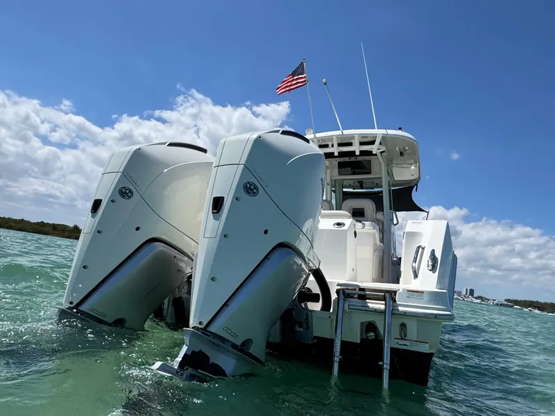 Slide: The Image of 2020 Boston Whaler 280 Outrage boat with dual engines on water, American flag flying. - 4