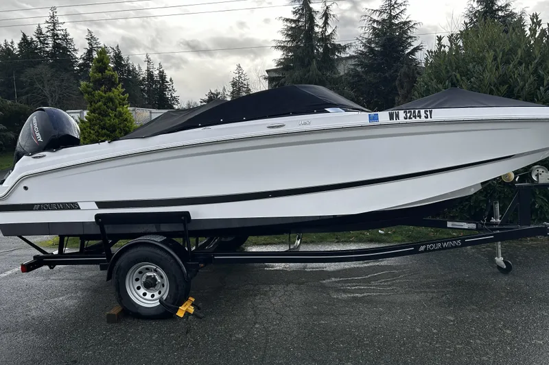 Slide: The Image of 2021 Four Winns HD2 OB boat on trailer, covered, with Mercury outboard motor. - 11