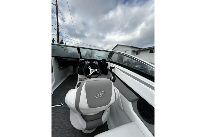Slide: The Image of 2021 Four Winns HD2 OB boat interior with steering wheel and seating under cloudy sky. - 18