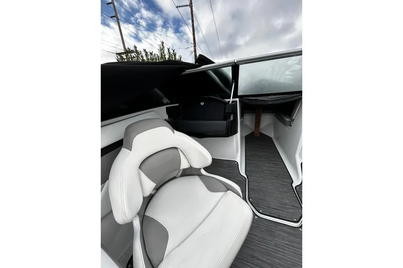 Slide: The Image of 2021 Four Winns HD2 OB boat interior with white and gray seating under a cloudy sky. - 19