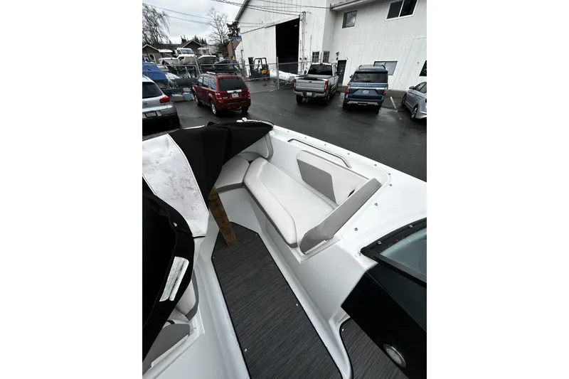 Slide: The Image of 2021 Four Winns HD2 OB boat interior with white seating, parked in a lot. - 20