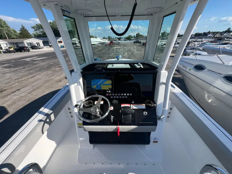 Slide: The Image of 2026 Wellcraft 243 Fisherman boat cockpit with steering wheel and navigation system. - 12