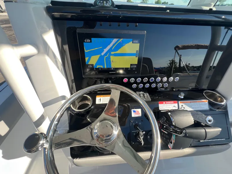 Slide: The Image of 2026 Wellcraft 243 Fisherman dashboard with steering wheel and navigation display. - 13