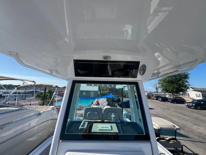 Slide: The Image of 2026 Wellcraft 243 Fisherman boat interior view at marina, showcasing helm and seating area. - 16