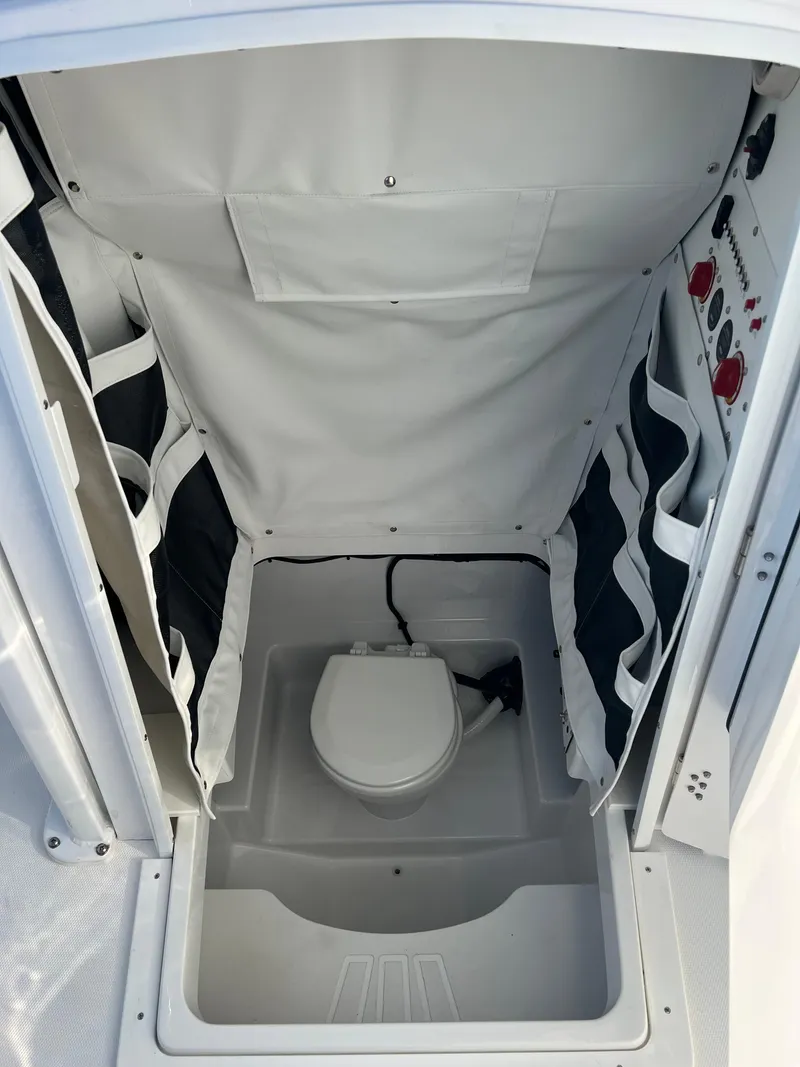 Slide: The Image of 2026 Wellcraft 243 Fisherman boat interior with compact marine toilet. - 18