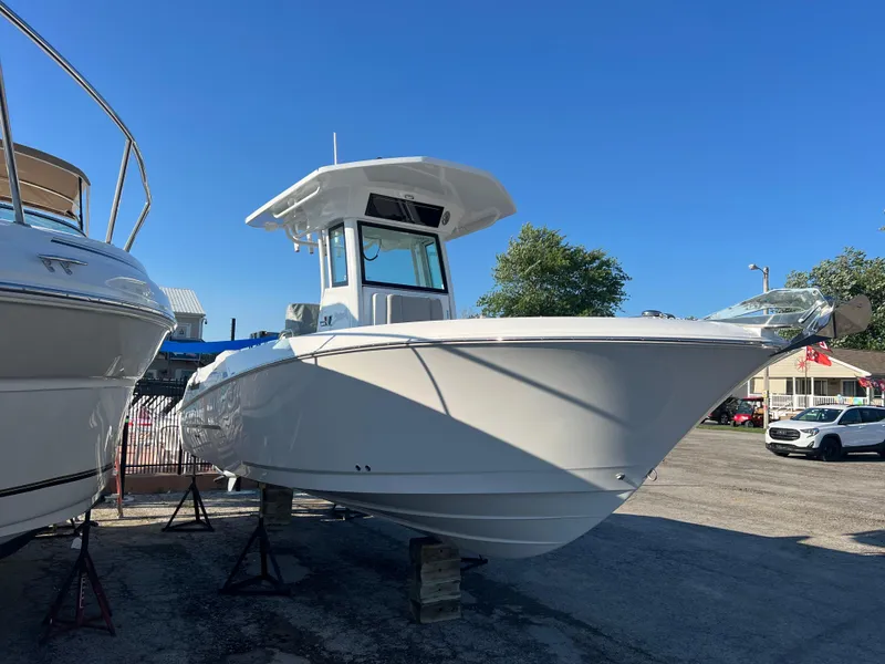Slide: The Image of 2026 Wellcraft 243 Fisherman boat displayed outdoors on stands, clear blue sky background. - 3