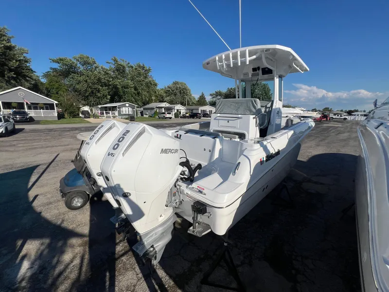 Slide: The Image of 2026 Wellcraft 243 Fisherman boat with dual Mercury outboard engines, parked outdoors. - 4