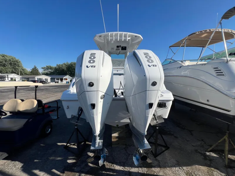 Slide: The Image of 2026 Wellcraft 243 Fisherman boat with dual 200 V6 engines, parked outdoors. - 5