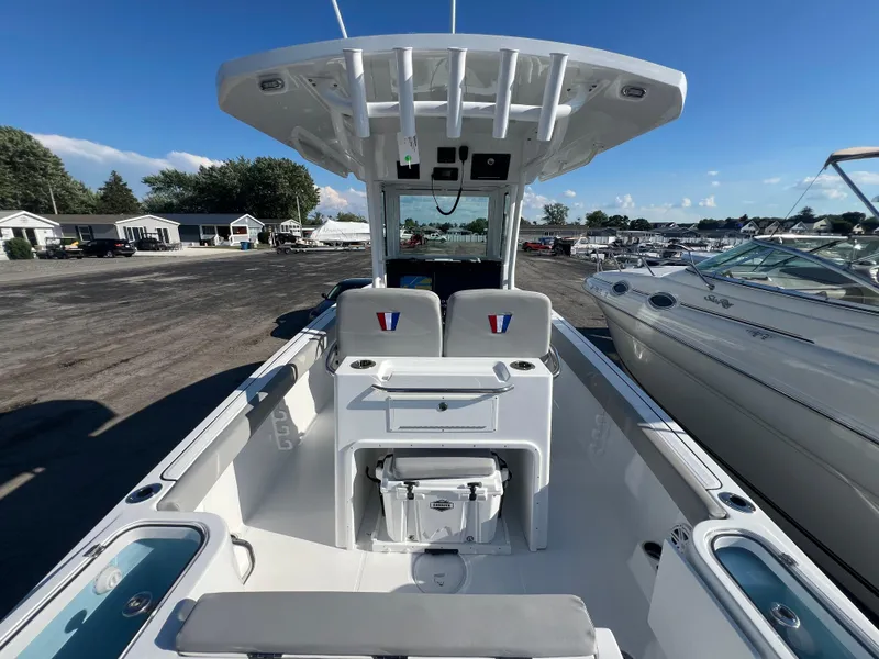 Slide: The Image of 2026 Wellcraft 243 Fisherman boat interior with seating and storage, docked at marina. - 7