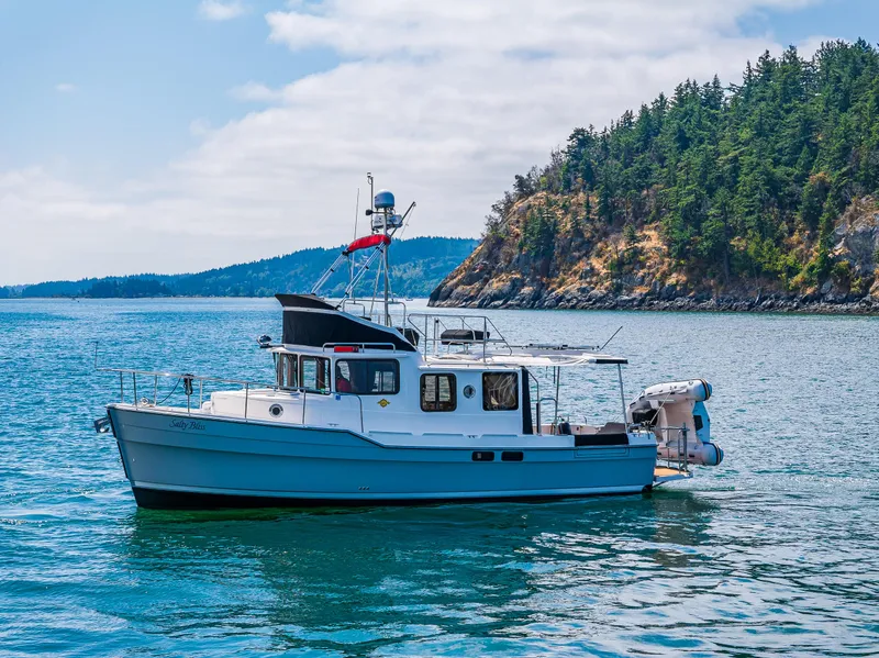 Slide: The Image of 2021 Ranger Tugs R-31 CB boat on scenic water with forested island background. - 10