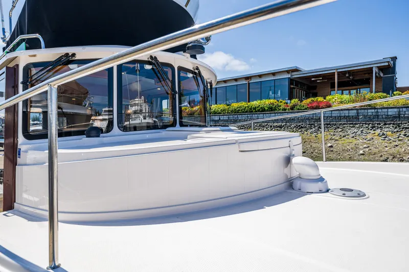 Slide: The Image of 2021 Ranger Tugs R-31 CB boat docked near a modern building with landscaped surroundings. - 18