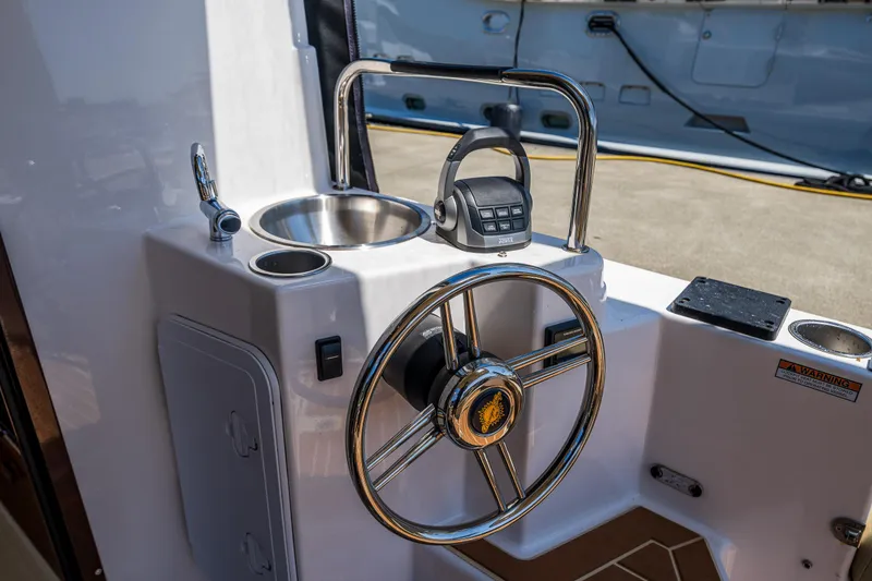 Slide: The Image of 2021 Ranger Tugs R-31 CB helm with steering wheel, sink, and controls. - 19