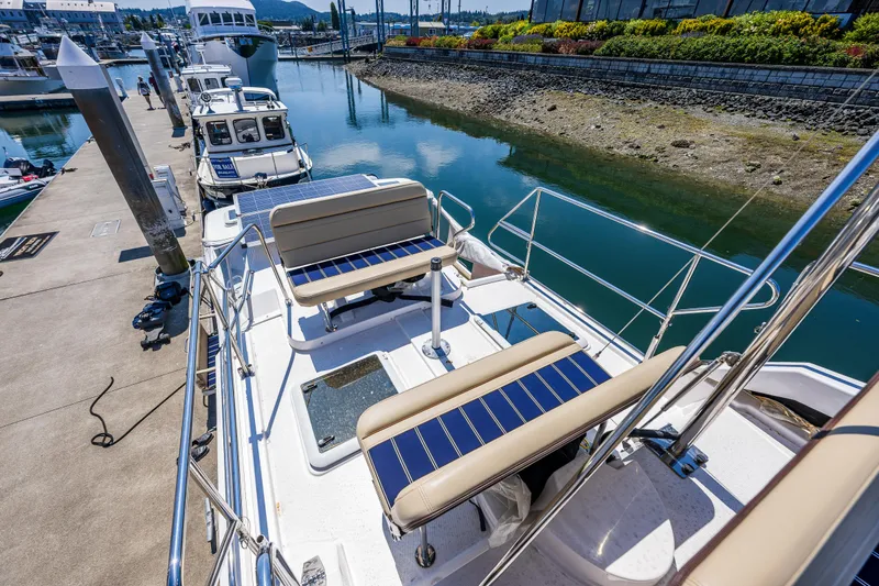 Slide: The Image of 2021 Ranger Tugs R-31 CB docked, featuring spacious deck seating and scenic marina view. - 21