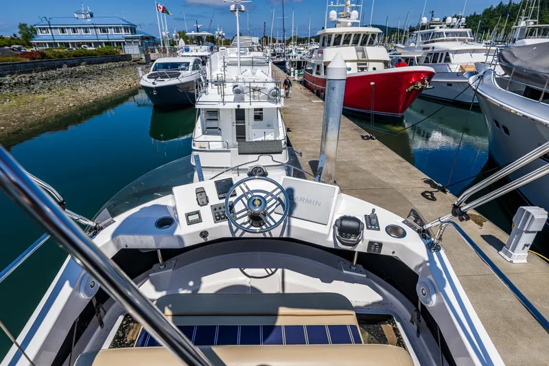Slide: The Image of 2021 Ranger Tugs R-31 CB at marina, surrounded by boats, clear sky. - 22