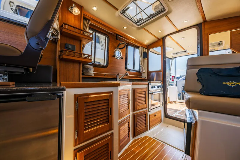 Slide: The Image of Interior of 2021 Ranger Tugs R-31 CB, featuring wood cabinetry and modern amenities. - 28
