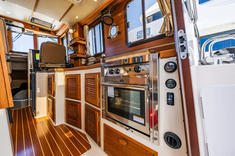 Slide: The Image of Interior of 2021 Ranger Tugs R-31 CB with wood accents and modern appliances. - 29