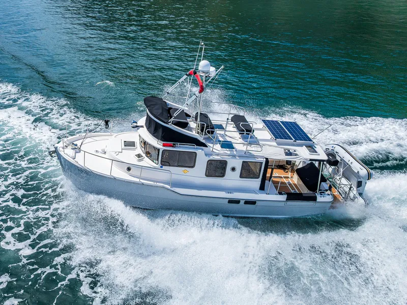 Slide: The Image of 2021 Ranger Tugs R-31 CB cruising on water, showcasing sleek design and solar panels. - 3