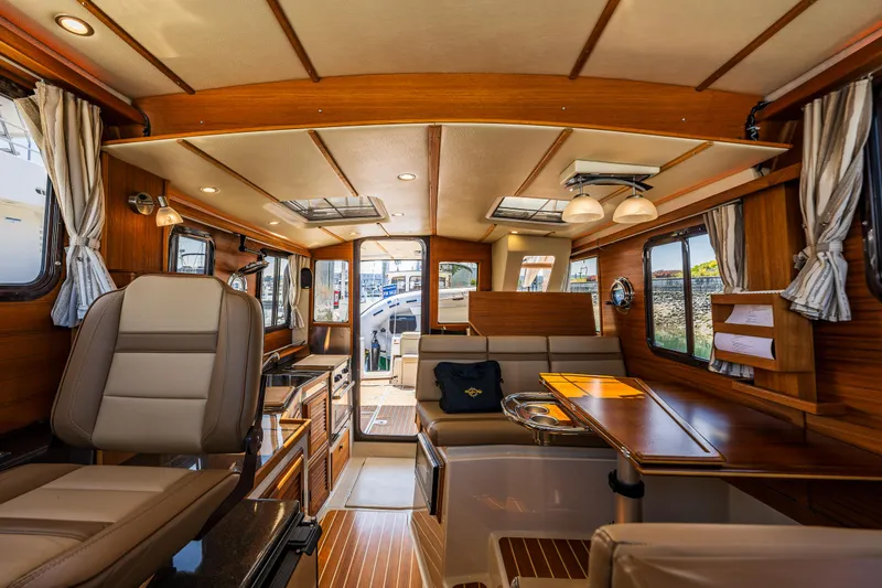 Slide: The Image of Interior of 2021 Ranger Tugs R-31 CB, featuring elegant wood finishes and modern seating. - 32