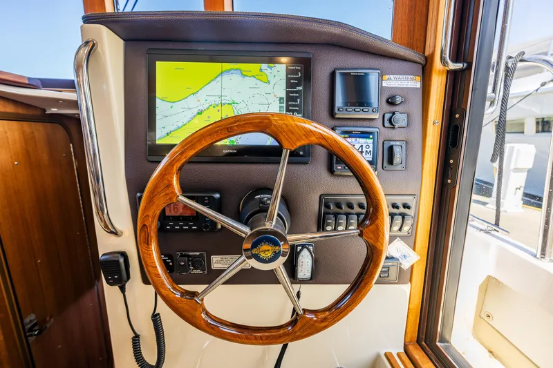 Slide: The Image of 2021 Ranger Tugs R-31 CB helm with wooden steering wheel and navigation display. - 33