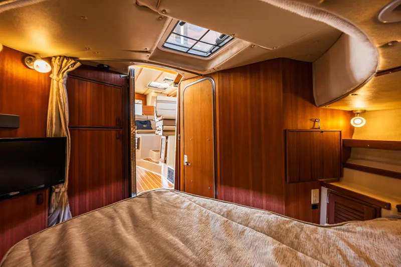 Slide: The Image of 2021 Ranger Tugs R-31 CB cabin interior with wood paneling and cozy lighting. - 34