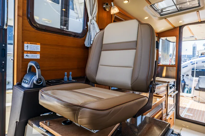 Slide: The Image of Captain's chair in 2021 Ranger Tugs R-31 CB boat interior, featuring luxurious design and controls. - 38
