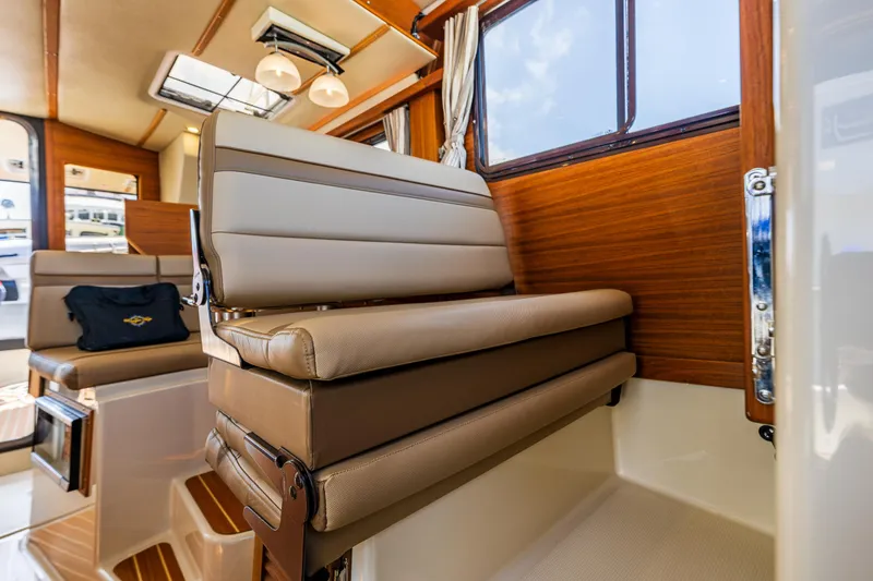 Slide: The Image of Interior of 2021 Ranger Tugs R-31 CB, featuring elegant seating and wood paneling. - 39