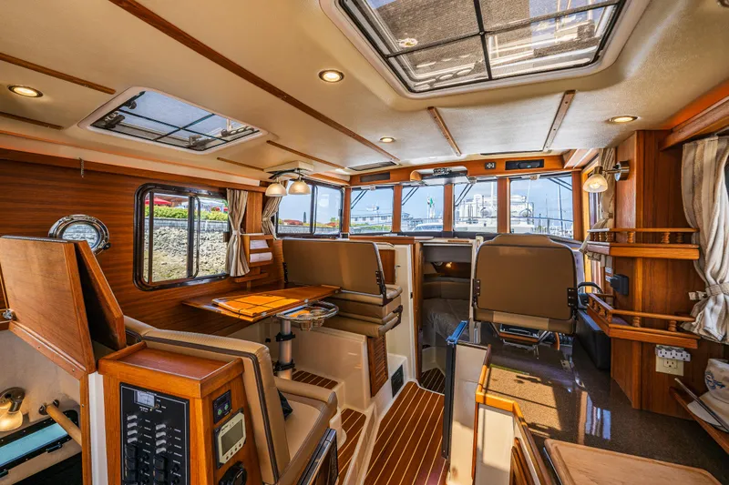 Slide: The Image of Interior of 2021 Ranger Tugs R-31 CB boat, featuring wood accents and spacious seating. - 40