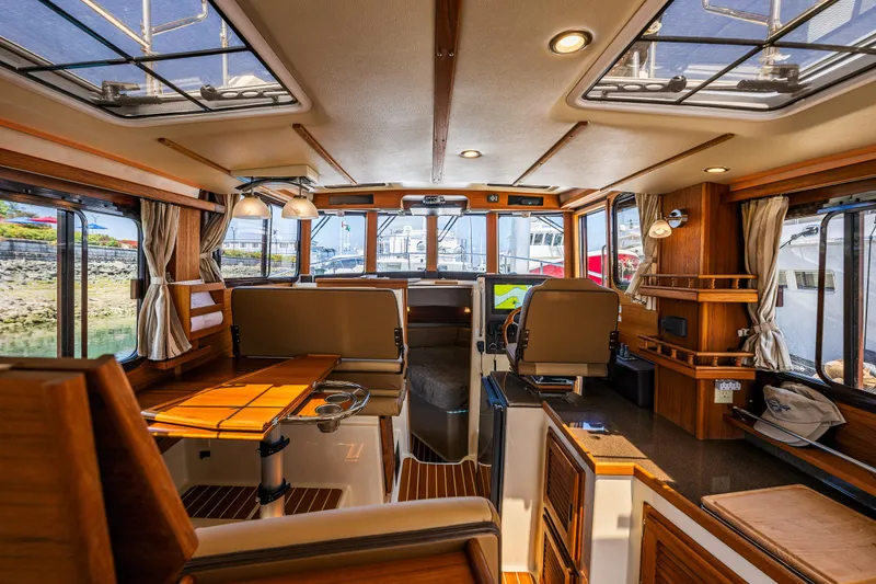 Slide: The Image of Interior of 2021 Ranger Tugs R-31 CB, featuring elegant wood finishes and modern navigation equipment. - 41