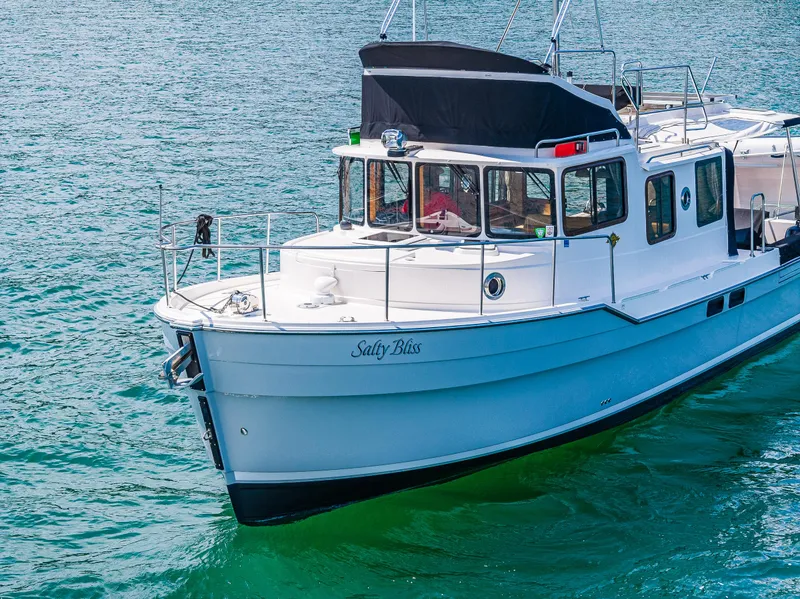 Slide: The Image of 2021 Ranger Tugs R-31 CB boat named "Salty Bliss" on clear blue water. - 5