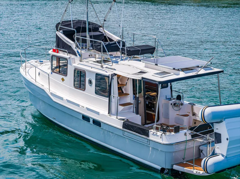 Slide: The Image of 2021 Ranger Tugs R-31 CB boat on water, featuring upper deck and solar panels. - 6