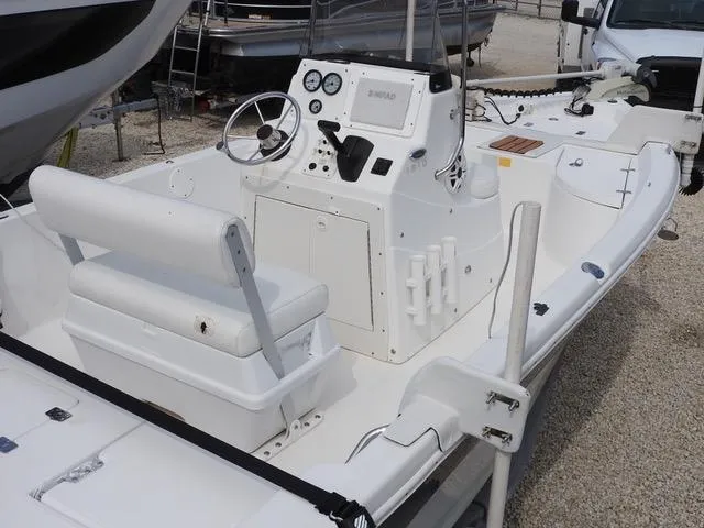 Slide: The Image of 2009 NauticStar 1810 Nautic Bay boat with steering console and seating, docked on gravel. - 11