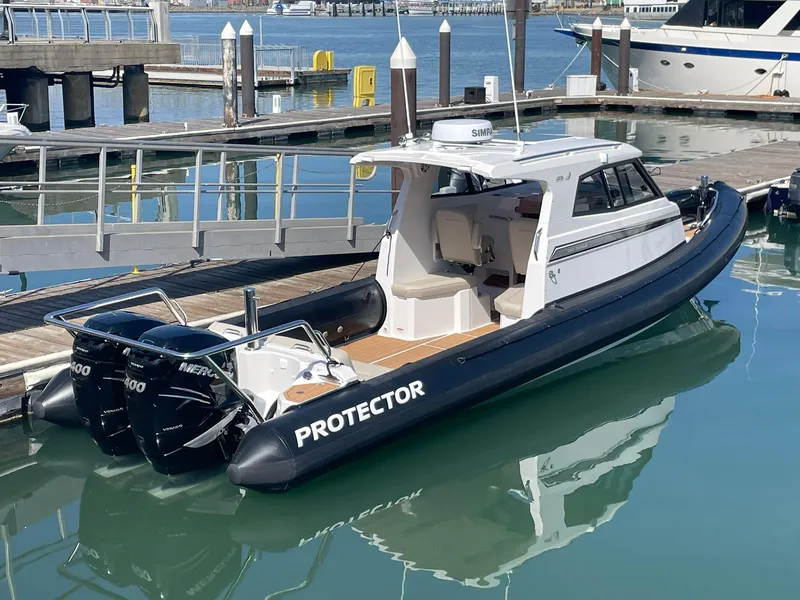 Slide: The Image of 2021 Protector 330 Targa boat with twin Mercury 350 HP engines docked in marina. - 21