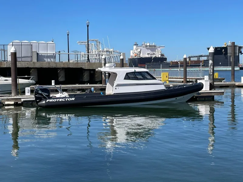 Slide: The Image of 2021 Protector 330 Targa boat docked, featuring twin Merc 350 HP engines. - 5