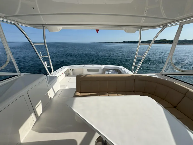 Slide: The Image of 2007 Viking 52 Open yacht interior with ocean view, featuring seating and table. - 19
